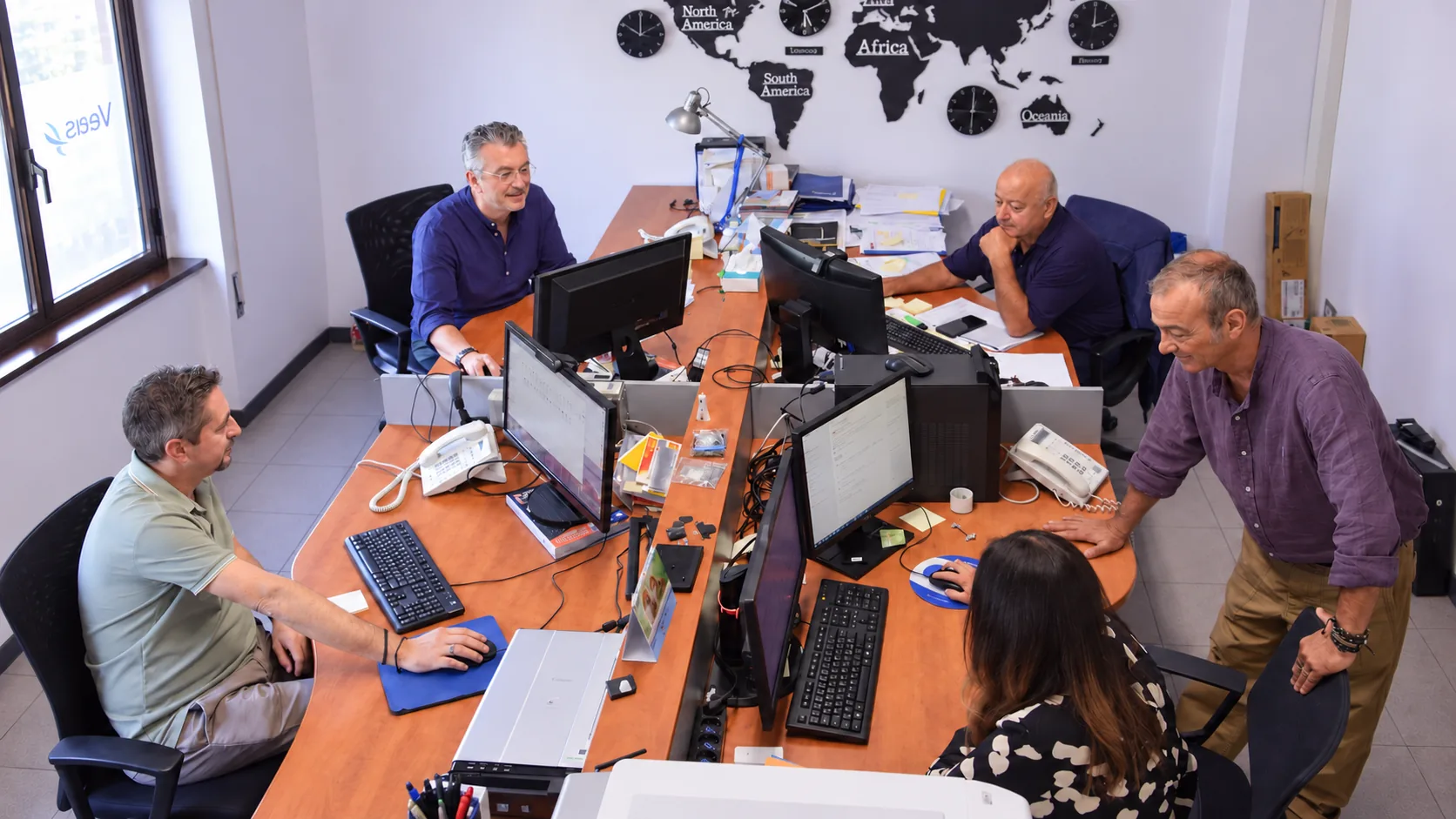 Il team VEAS al lavoro fra computer e postazioni nell’ufficio di Milano